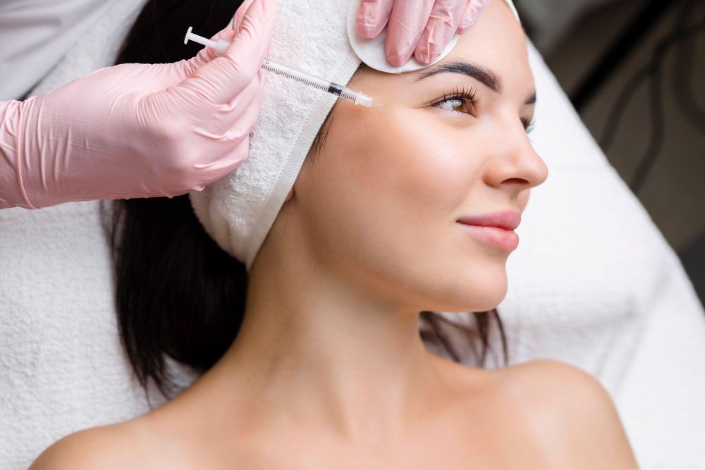Paciente sonriente recibiendo aplicación de baby botox en el rostro