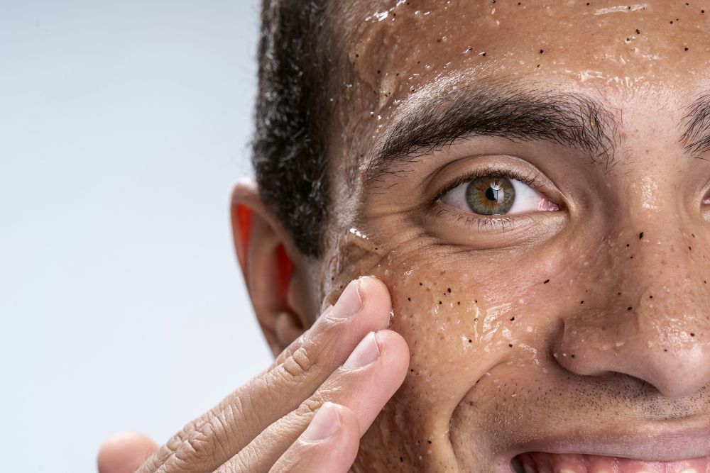 Hombre aplicando un tratamiento exfoliante en el rostro