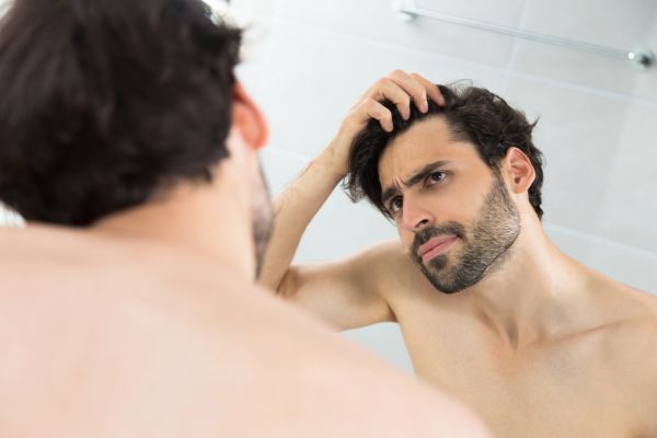 Hombre observando la pérdida de densidad capilar en la coronilla
