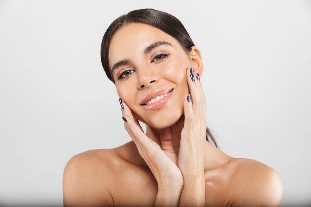 Mujer sonriente mostrando una piel luminosa y saludable tras seguir la rutina de skin cycling